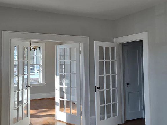 Hardwood floor and lovely natural light throughout. Living room view to dining room and hallway.