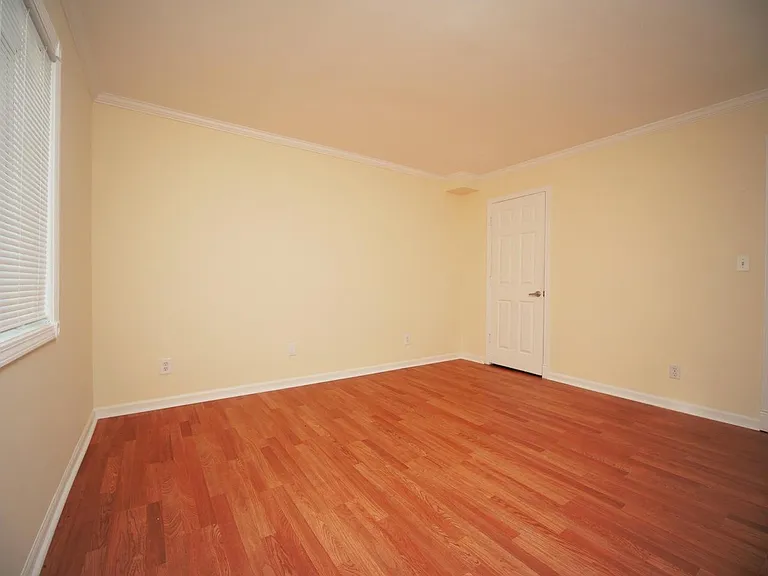 Bedroom with walk-in closet and window.