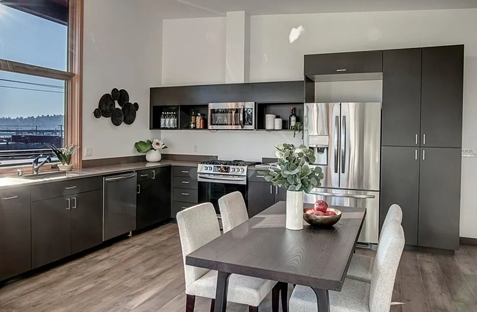 Light filled dining area and kitchen with gas range and stainless appliances