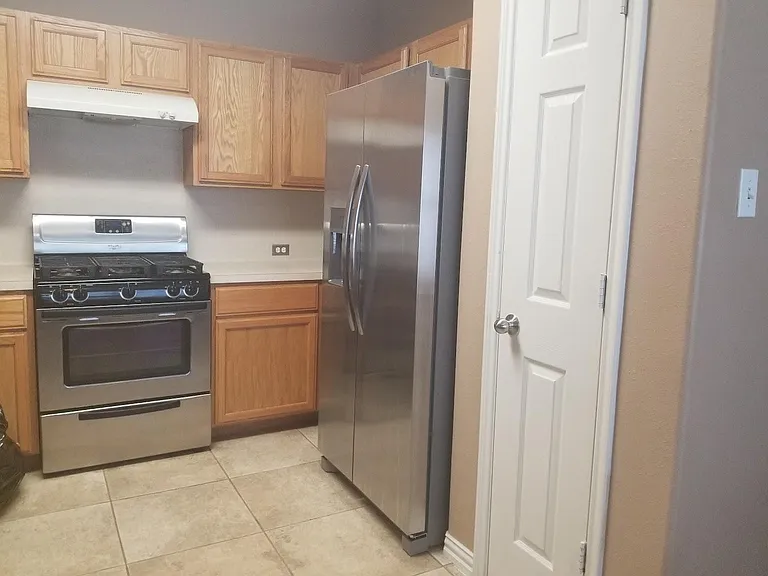 The kitchen includes a food pantry and a new stainless double-door refrigerator with an ice maker.