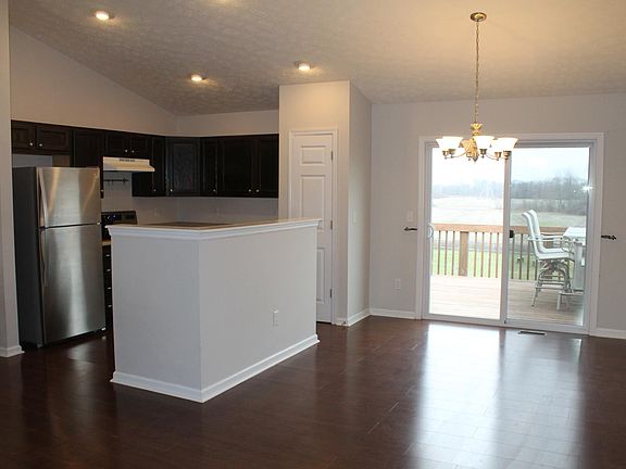 Open concept kitchen, dining, and sliding patio door access to deck