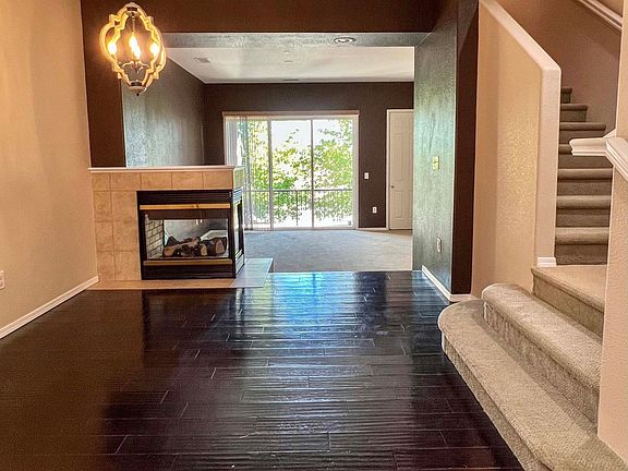 From kitchen looking past dining area to living room. Gas fireplace between dining area and living room. Stairs to bedrooms and laundry room.