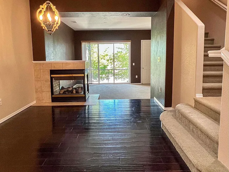 From kitchen looking past dining area to living room. Gas fireplace between dining area and living room. Stairs to bedrooms and laundry room.