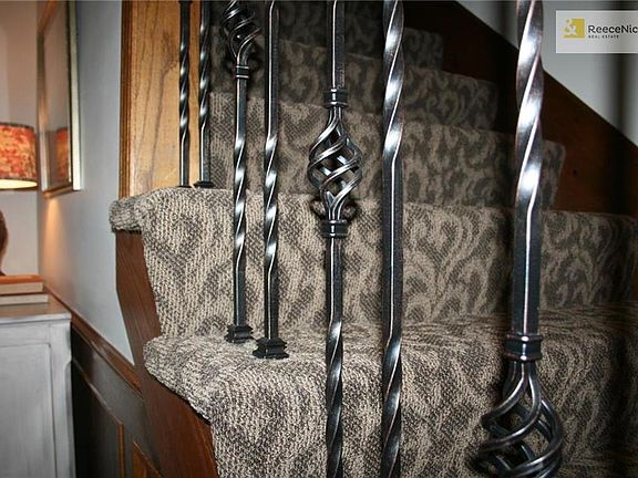New designer carpet covers the staircase with iron spindles.
