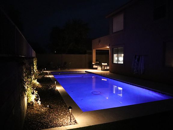 Stunning pool in elegantly landscaped backyard.