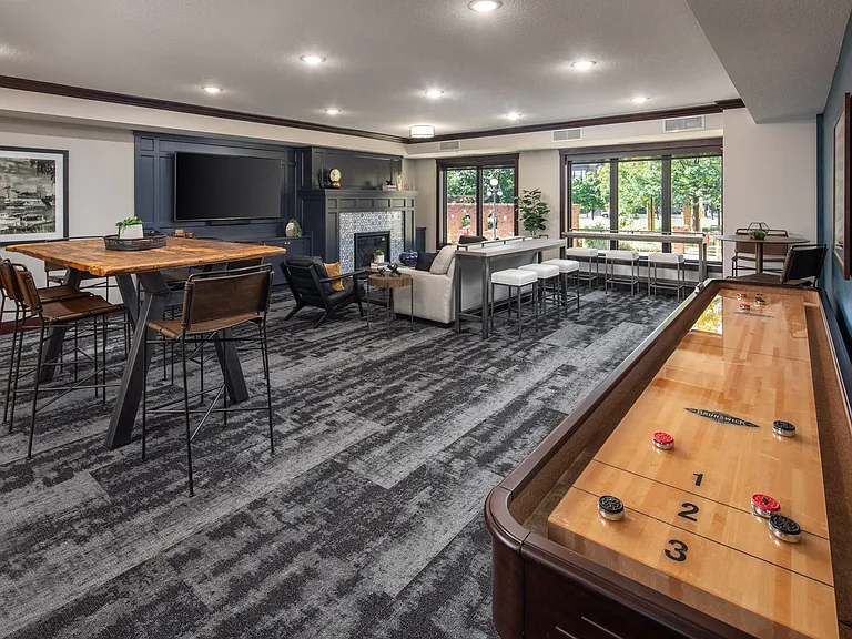 Indoor view of clubhouse equipped with game table and multiple seating areas at The Whitley.