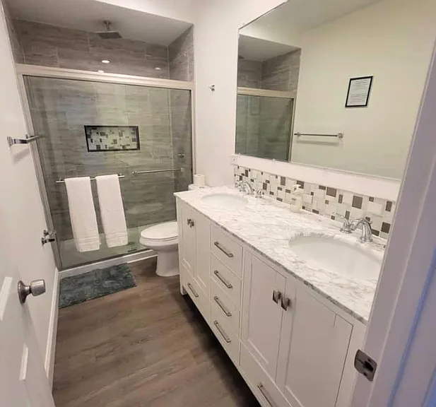 Impeccable modern bathroom with toilet, shower, sink, and essential amenities.