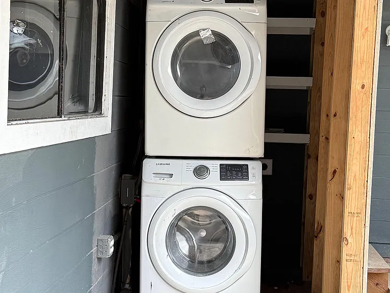 Dedicated laundry nook with a stacked Samsung washer and dryer for convenient in-home laundry.