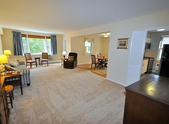 Large living room with golf course views and "L" shaped dining room. The living room has covered har