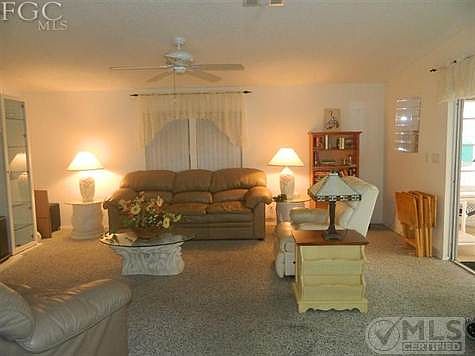 Living room has cathedral ceilings and opens onto lanai with view of canal leading to San Carlos Bay.