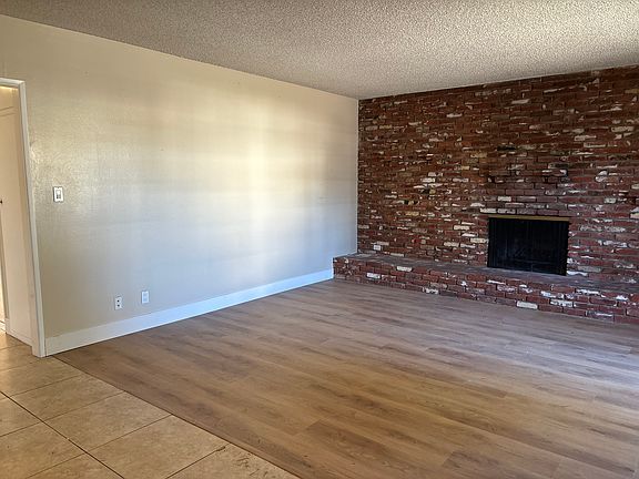Livingroom with new engineered hardwood flooring - custom used brick fireplace wall