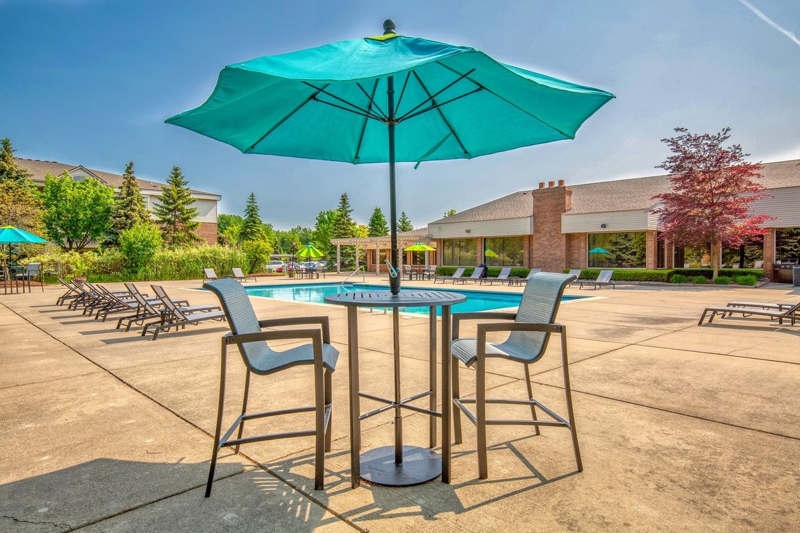 Heated Swimming Pool with lounge furniture at Prentiss Pointe Apartments in Harrison Township, MI