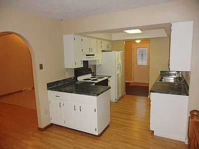 white galley kitchen with breakfast nook overlooking 2 story