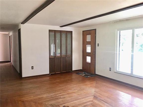 Another view of the living room and down the hall.  A handy coat closet is at the front door.  The hallway is a generous 44" wid