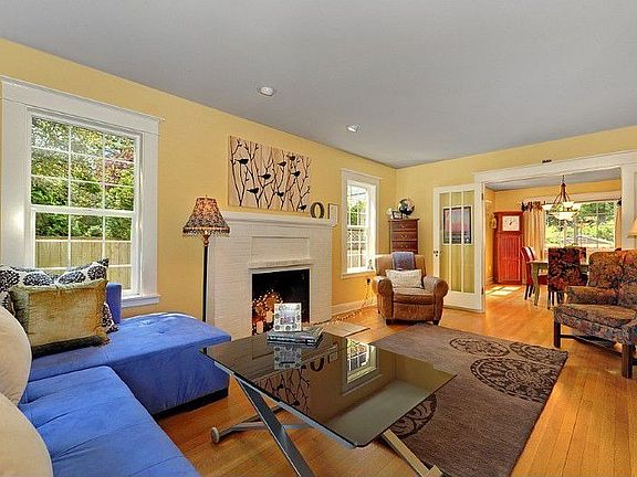 Light drenched living room with gleaming hardwood floors and french doors that lead to the formal di