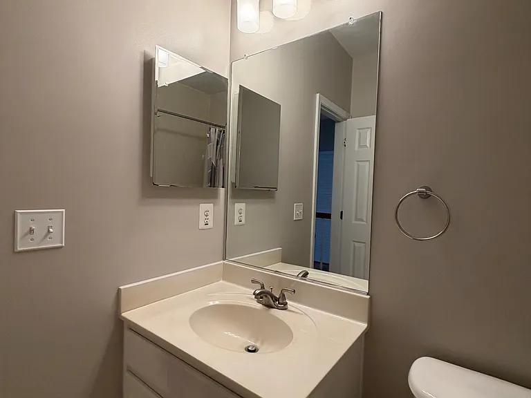 The well-appointed hall bathroom offers a spacious vanity, full tub/shower combination, vaulted ceiling, and modern finishes, providing comfort and convenience for family members and guests alike.