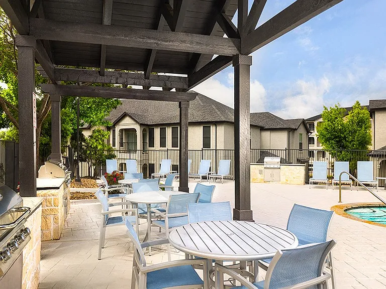 Outdoor built-in kitchen with grilling stations and dining