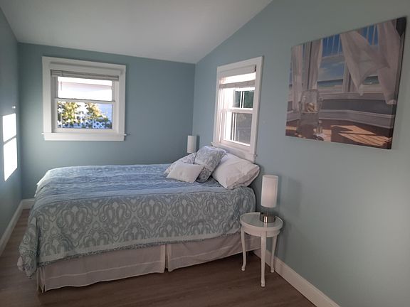 Primary bedroom with queen bed with cathedral ceilings and ceiling fan