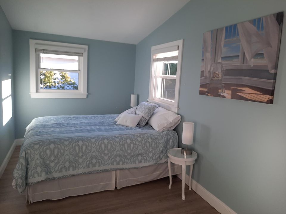 Primary bedroom with queen bed with cathedral ceilings and ceiling fan