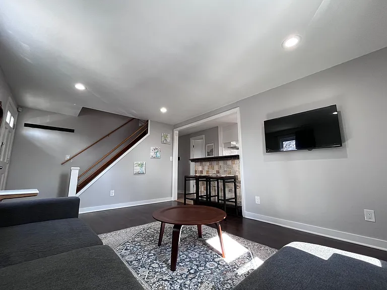 Open-concept living area with recessed lighting, durable flooring, and a breakfast bar seating area off the kitchen.