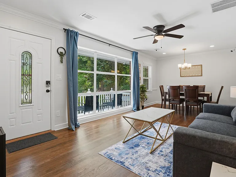 Open living and dining area with large picture window, ceiling fan, and easy-care flooringideal for relaxing or meals.