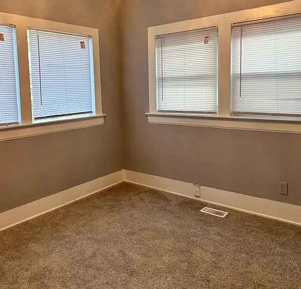 A cozy, light-filled room with abundant natural light, ideal for use as a den or guest room.