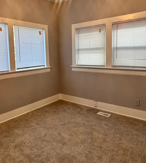 A cozy, light-filled room with abundant natural light, ideal for use as a den or guest room.