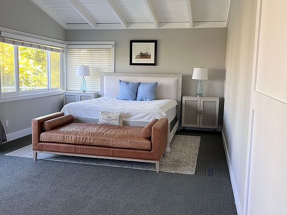 Primary bedroom with deck overlooking backyard and pool