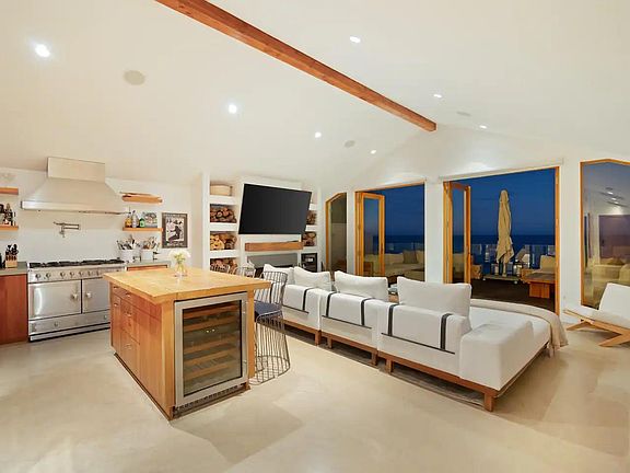 Large glass doors open to the rustic beachfront deck.