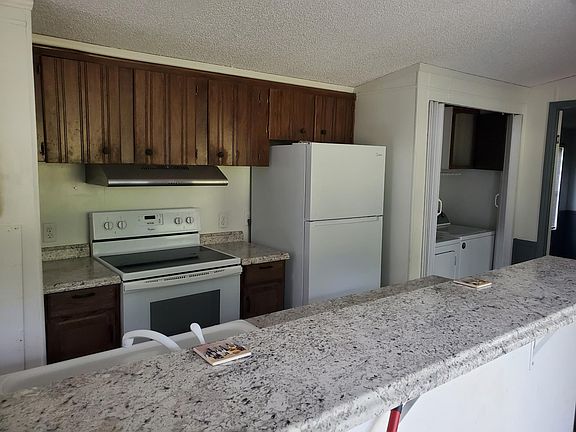 Smooth top range/oven, freezer/fridge, clothes washer/dryer, island with raised bar.