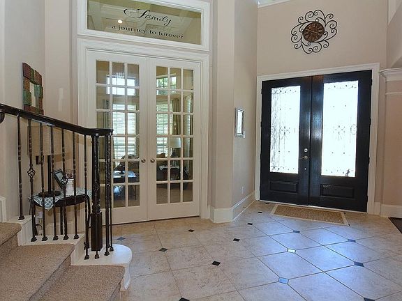 Elegant entry with tile floors and wrought iron stair rails.
