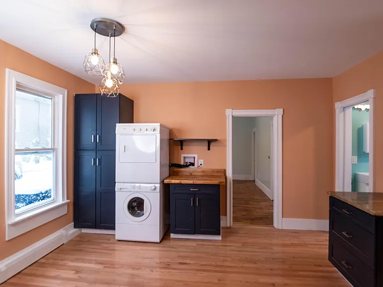 front view of laundry area and additinal cabinets doors to bathroom and living room