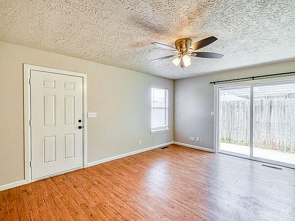 Living room with view of front door and patio door to the patio and backyard