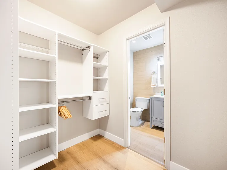 This stylish walk-in closet offers ample storage with shelves, hanging rods, and drawers, keeping everything organized and within reach. Its sleek design and bright lighting create a functional and luxurious space for your wardrobe.