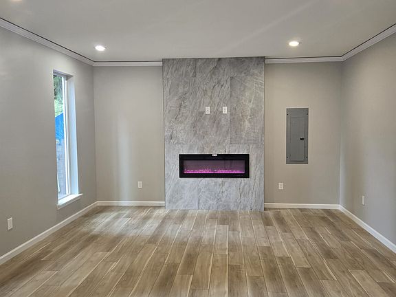 Living room with decorative LED fireplace and power/internet/cable points to install TV
