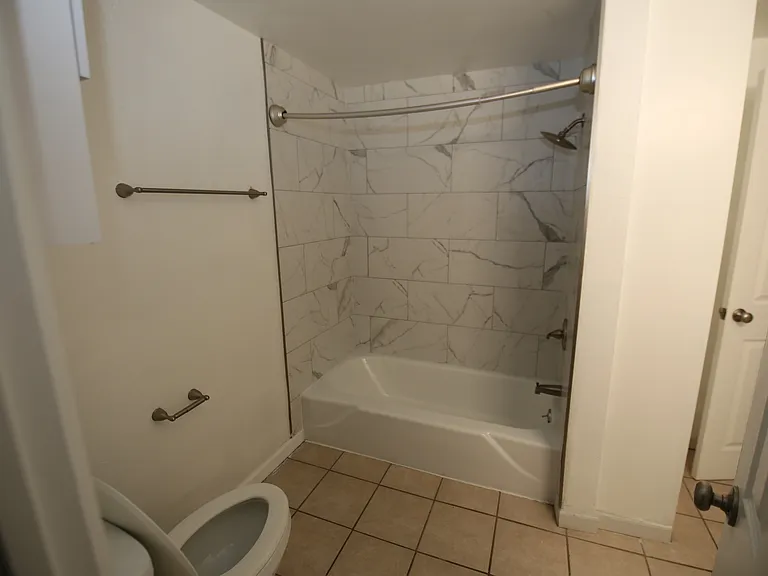 Modern bathroom with elegant marble tile shower and sleek fixtures, offering a serene and stylish retreat.