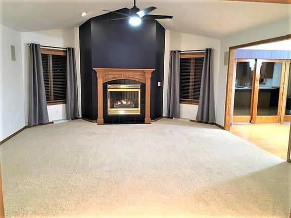 Living room with high ceilings and gas fireplace. Speakers for surround sound.