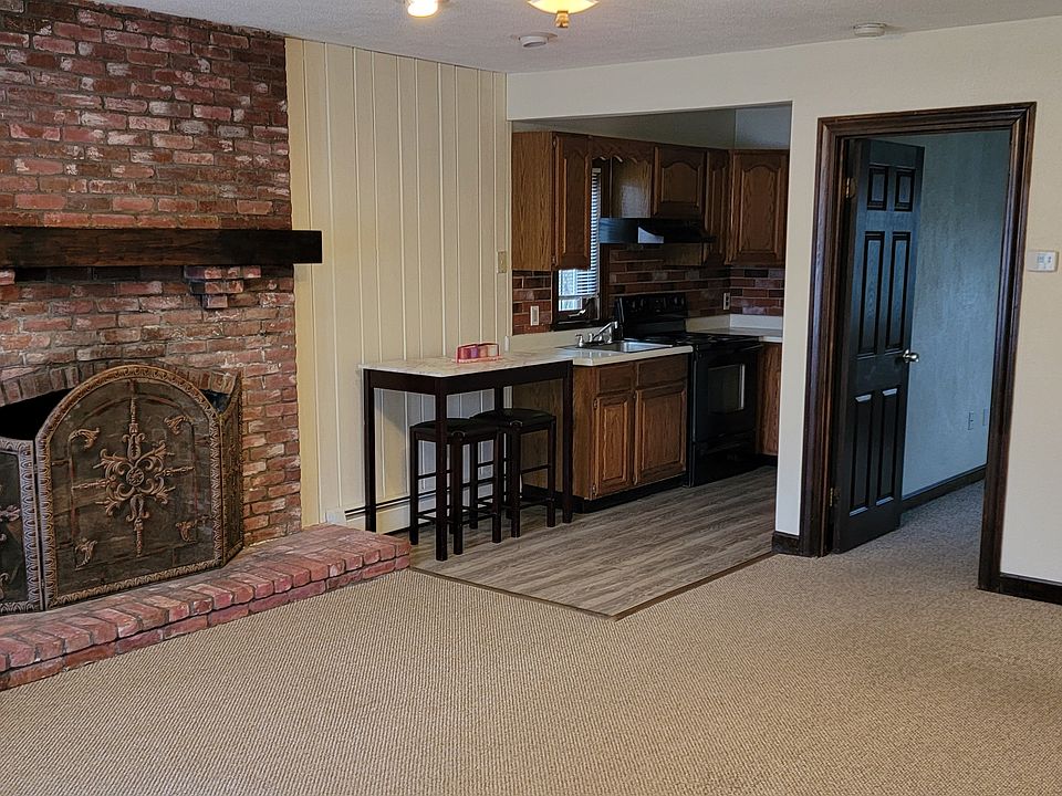 Fireplace in living room, galley kitchen, door way into 1st bedroom