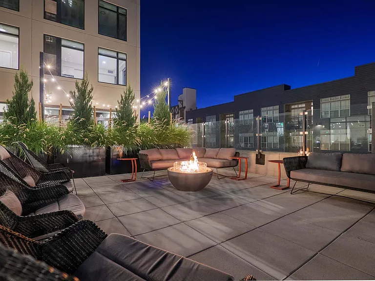 Gather on a large couch around the fire pit on the spacious patio, perfect for evening conversations.