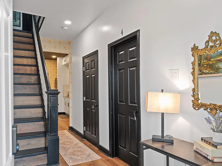 Welcoming entry hallway with staircase, hardwood-style floors, and recessed lighting for easy access to upper rooms.