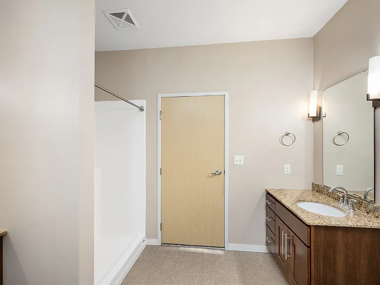 Modern bathroom with elegant granite countertop, large mirror, and stylish lighting fixtures. Modern bathroom with elegant granite countertop, large mirror, and stylish lighting fixtures.