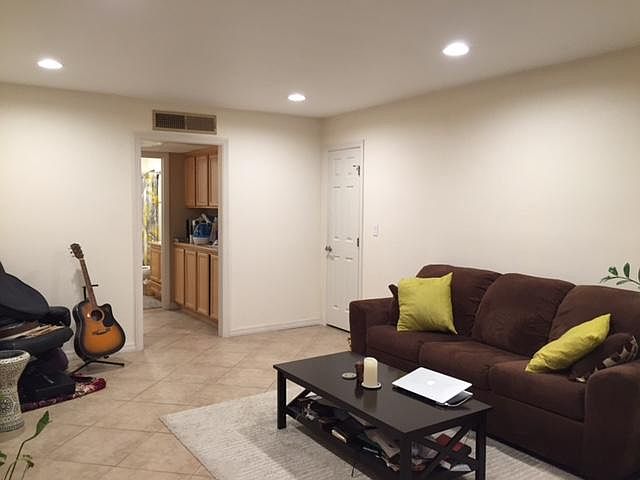 Open concept living room flows into dining area to the left of the image. You can also see plentiful linen closets