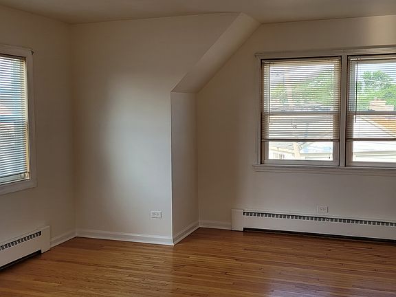The large sunny open living and dining room with hardwood floors and lots of windows.