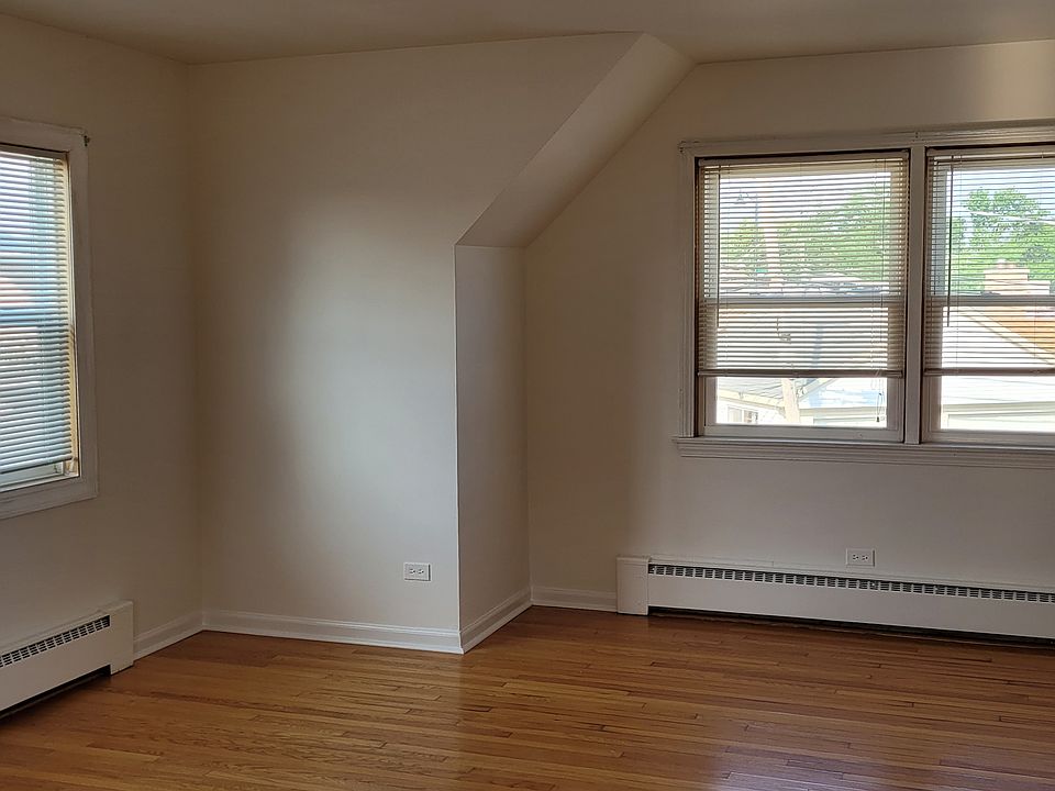 The large sunny open living and dining room with hardwood floors and lots of windows.