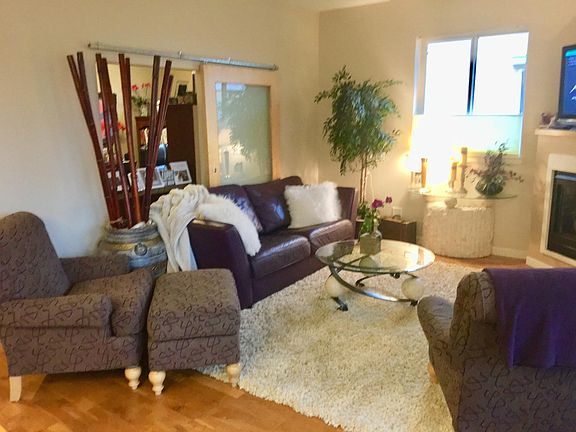 Living room with glass barn door into second bedroom/office