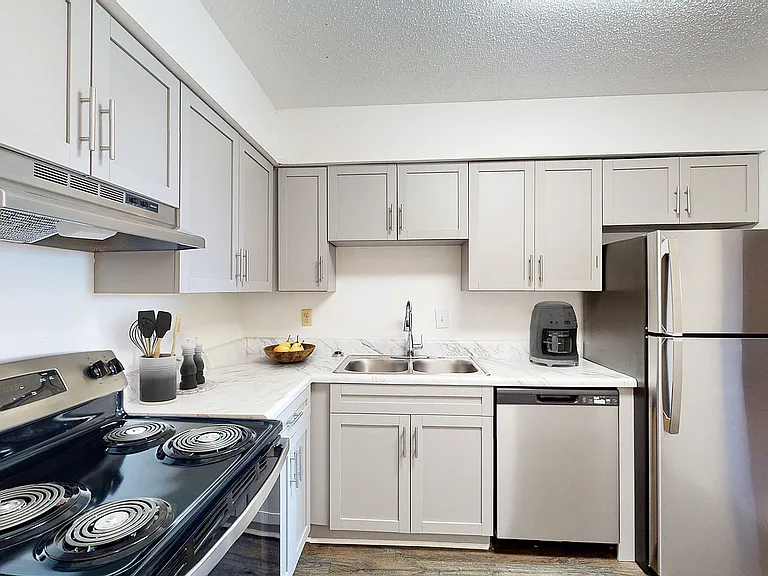 Kitchen with granite counters, modern cabinetry, and stainless appliances