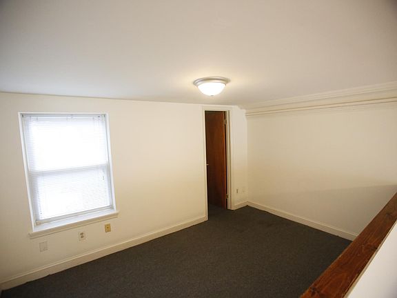 bedroom space with a small window, and storage