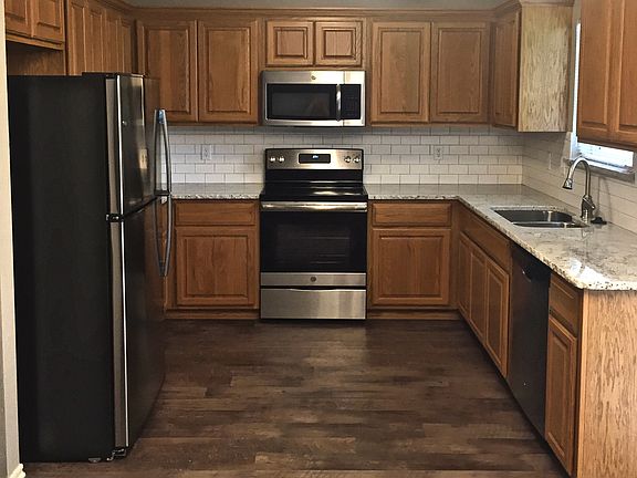 Kitchen with stainless steel appliances, dishwasher, microwave, and electric stove.