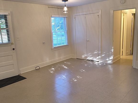 Living room view of double closet and hallway leading to bedroom and bathroom
