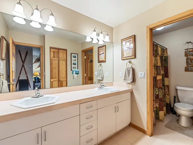Lower level full bathroom with double sinks, tub and shower